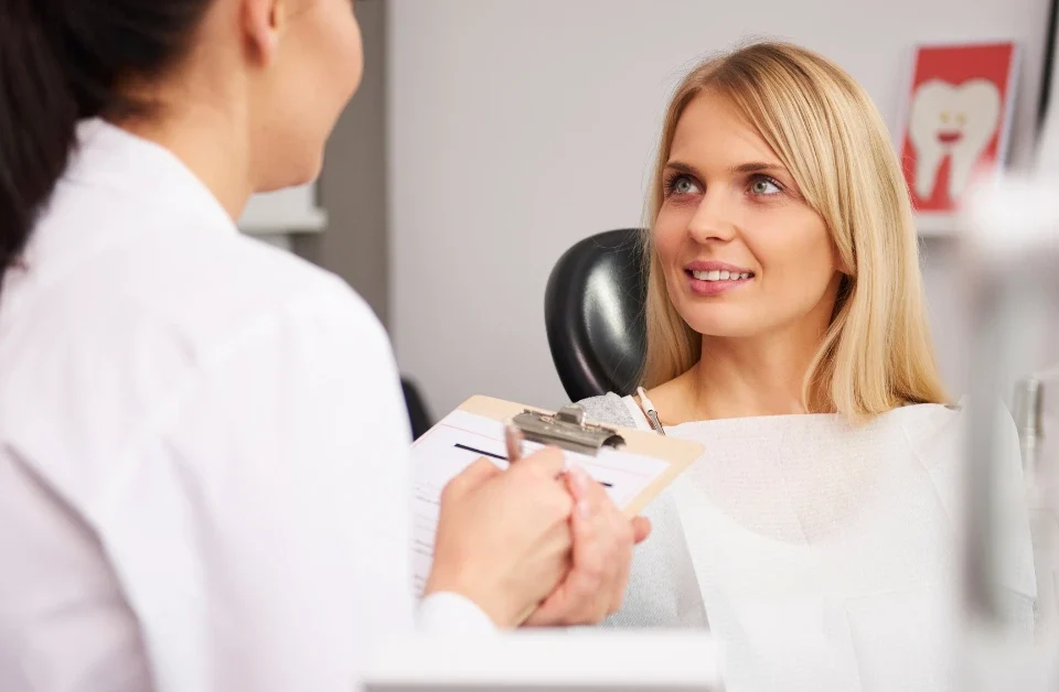 Dentist consulting with smiling patient about root canal treatment options in modern dental office