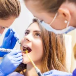 Dentist examining patient’s teeth to check why some people get cavities more easily than others.