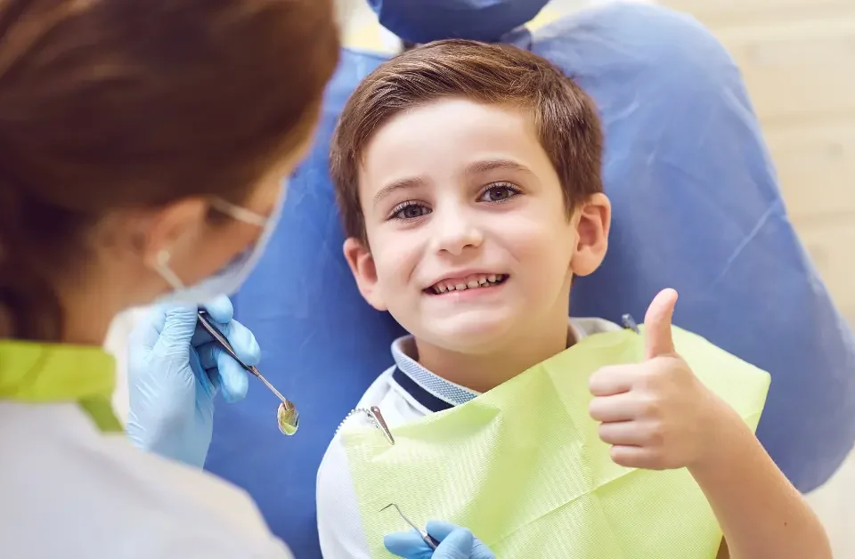 Child receiving dental checkup for healthy teeth at pediatric dentist office with caring dental professional