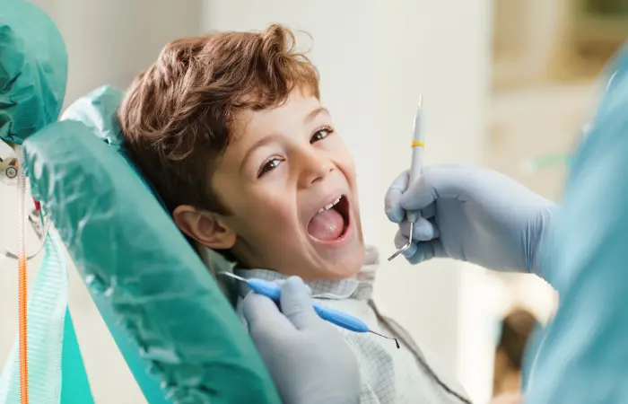 Happy child smiling in dental chair showing positive experience for healthy teeth and pediatric dental care